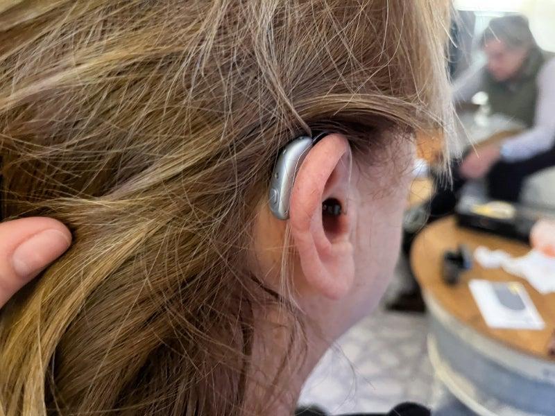 A close-up shot of a woman wearing the Jabra Enhance Select 700 hearing aid