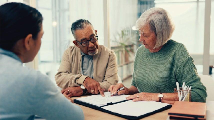 A retired couple is talking to a financial adviser about their estate plan and will and trust.