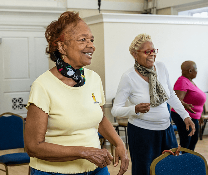 smiling older women in senior center dance class