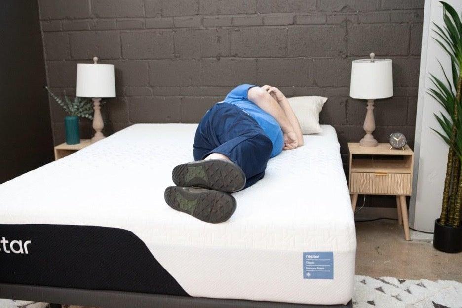 A higher-weight man lies on his side on the Nectar Premier Memory Foam mattress