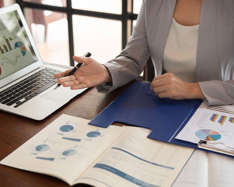 A business woman is reviewing financial statements with her older adult client.