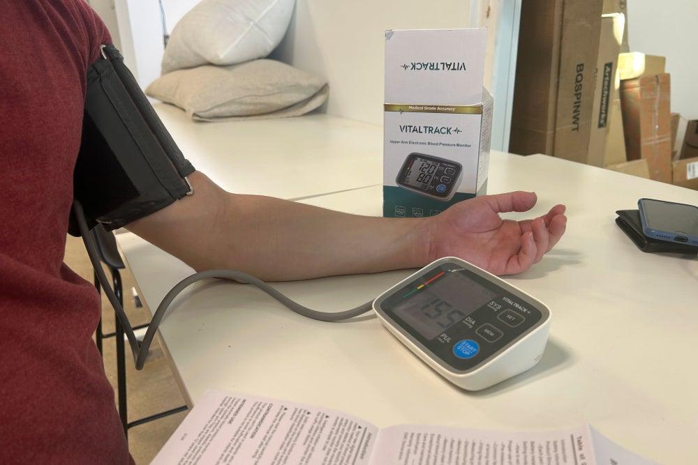 A man taking his blood pressure with the VitalTrack Pro