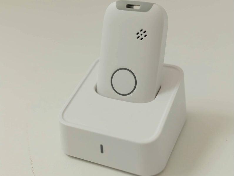 The white MobileHelp Elite in its charging cradle