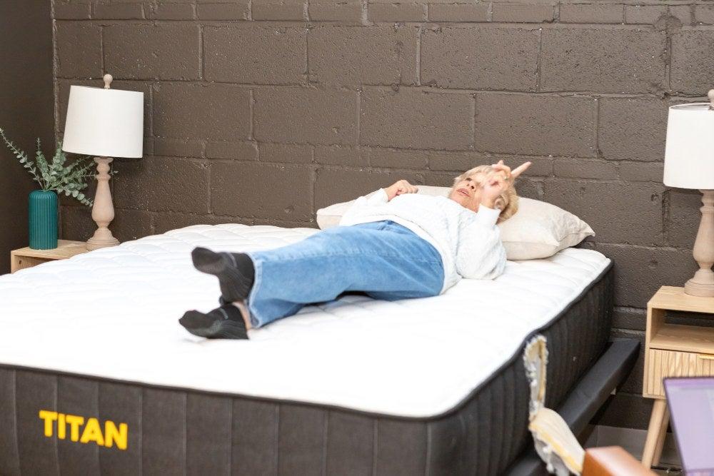 A woman lying on her back on the Titan Plus mattress