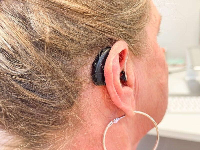 A woman wearing the Soundbright Discovery behind-the-ear hearing aids