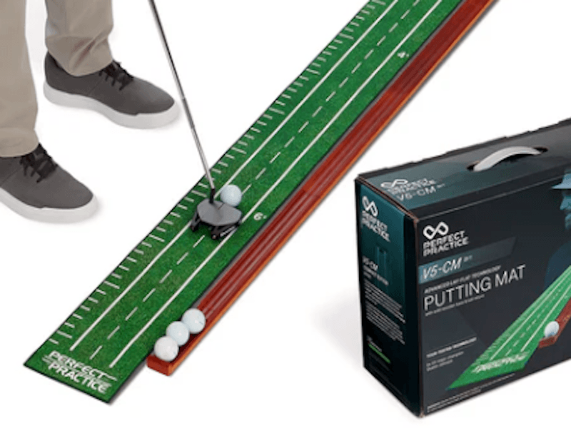 Person putting on a green practice mat, with golf balls lined up.