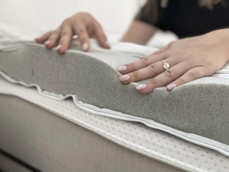 A woman exposes the inner memory foam of a Bear Pro Topper
