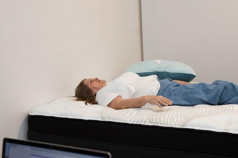A woman lying on her back on the Nolah Evolution Luxury Firm mattress