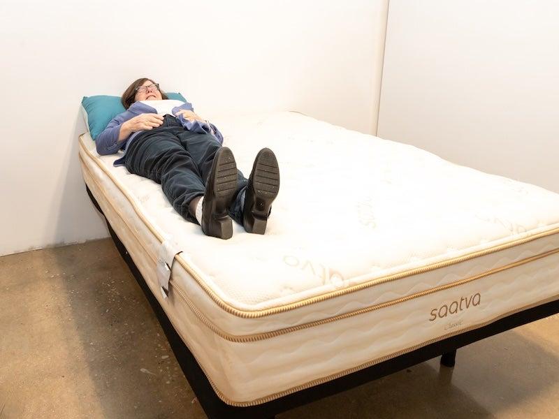A female tester tries out the Saatva Classic on her back