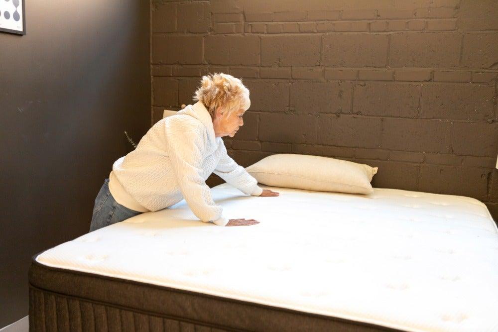 A woman runs her hand over the Titan Plus mattress’s surface