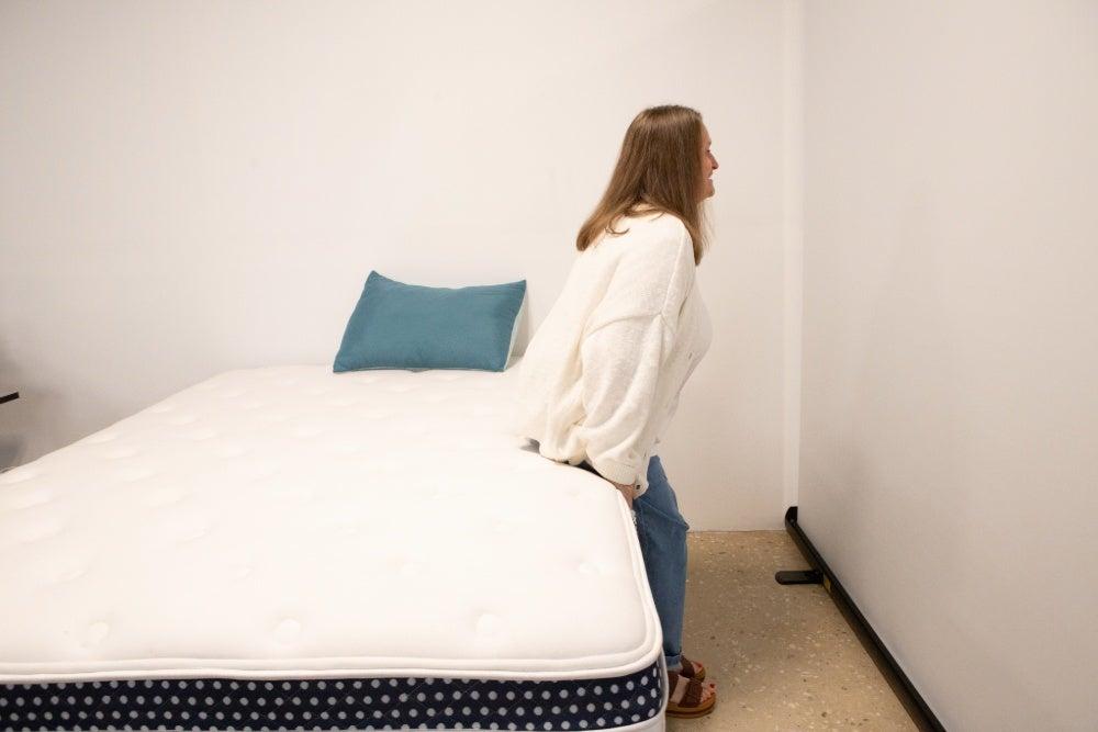 A woman sitting on the edge of the WinkBed Plus mattress