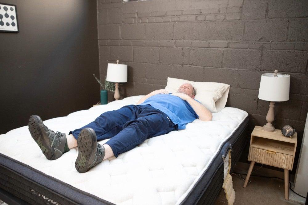 A man lying on his back on the Helix Midnight Luxe mattress