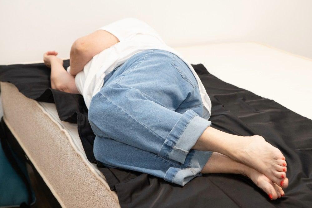 A woman lying on her side on the Birch Natural mattress