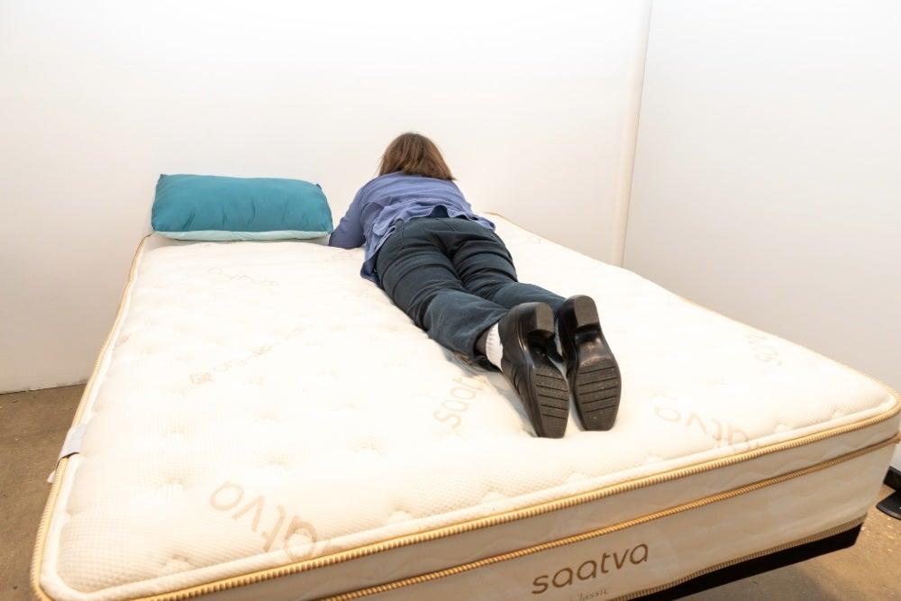 woman lying on her stomach on top of the Saatva Classic mattress