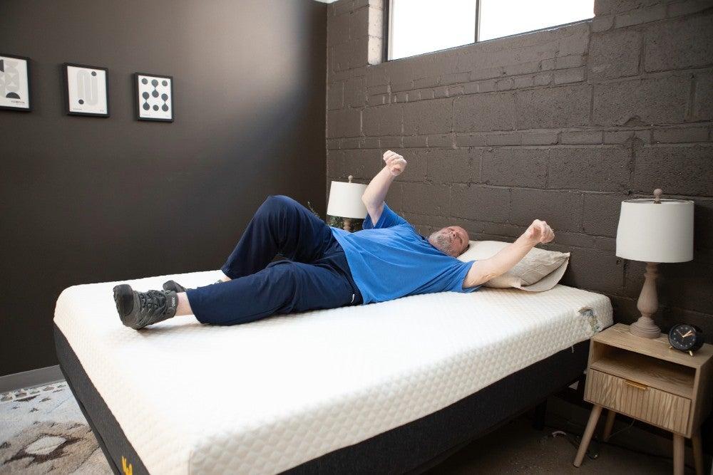 An older adult man rolling over on the Nolah Signature mattress
