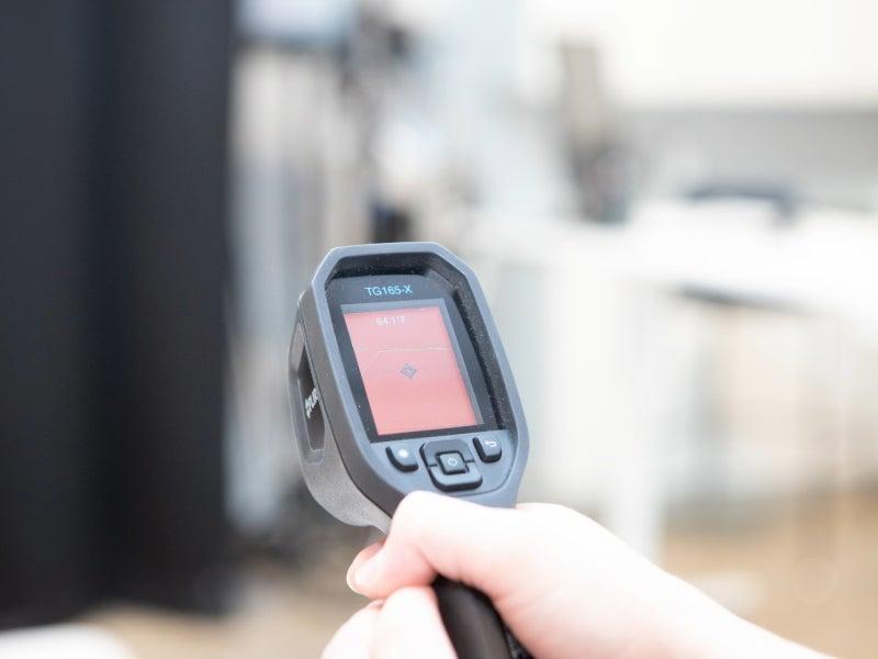 A temperature gun showing 64 degrees F