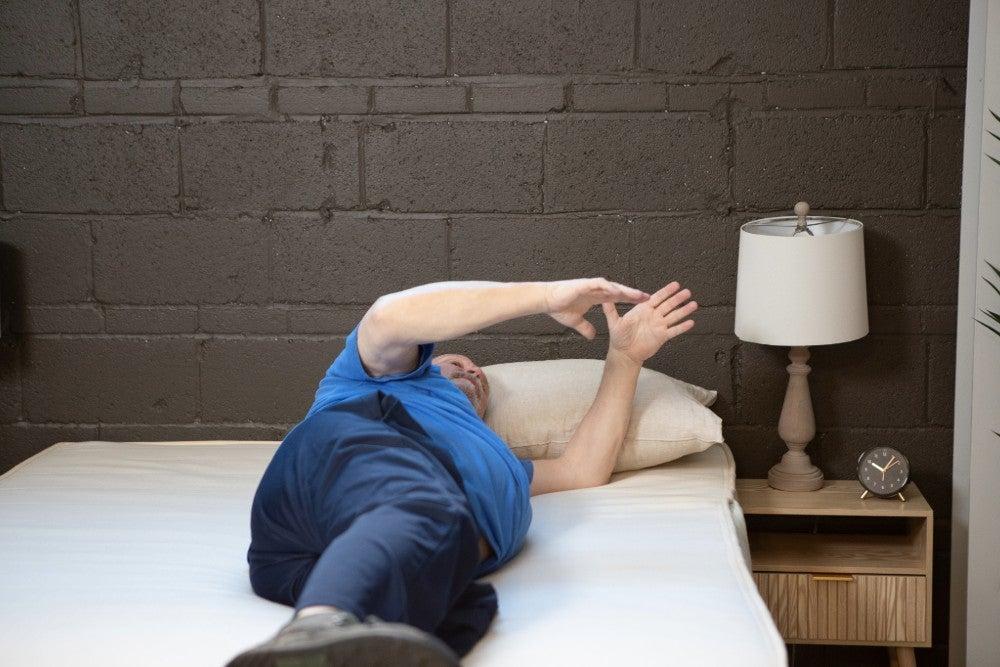 An older adult man rolling over on the Birch Natural mattress
