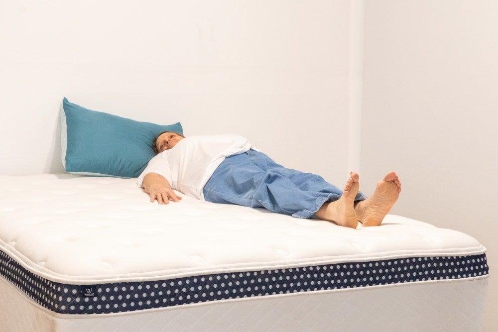 A woman lying on her back on the WinkBed Plus