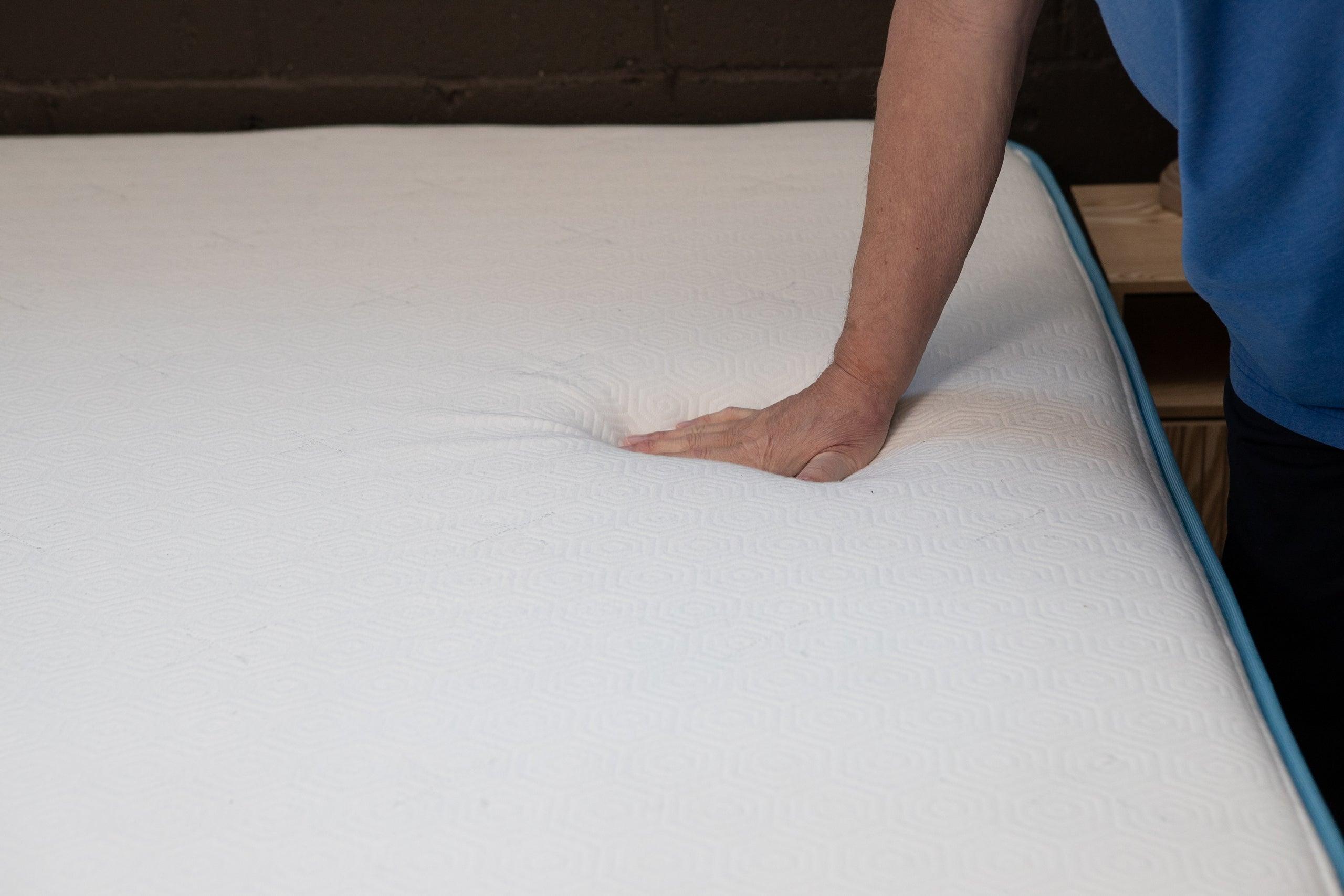 A man pressing down on the surface of the Bear Original mattress