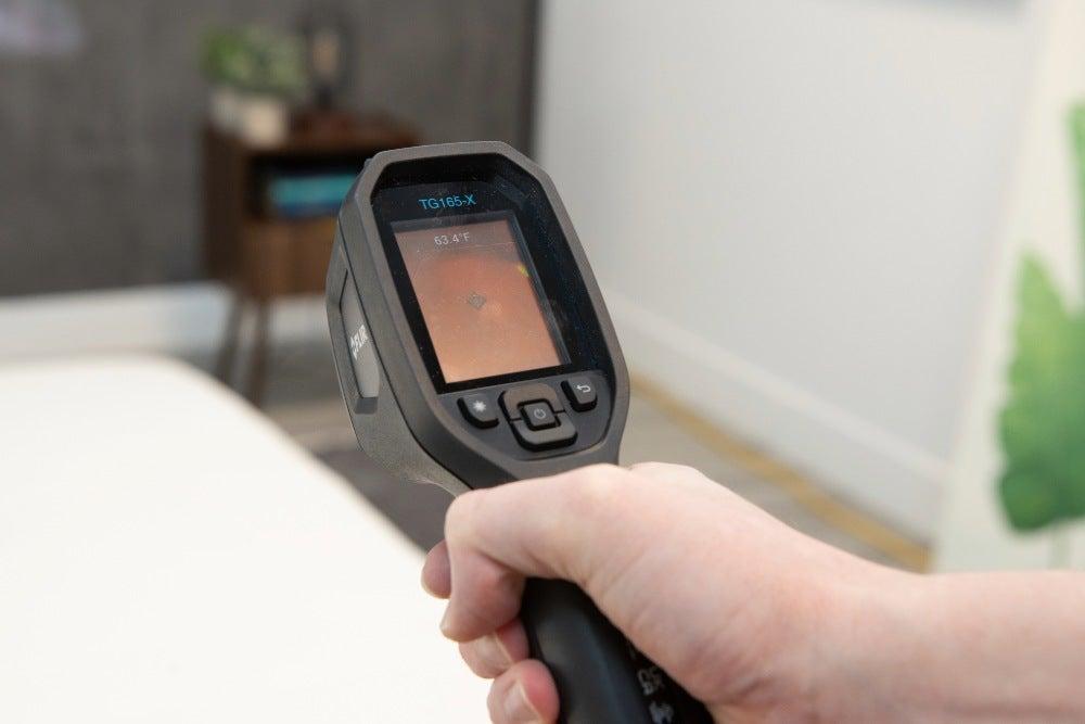 A temperature gun pointed at a mattress