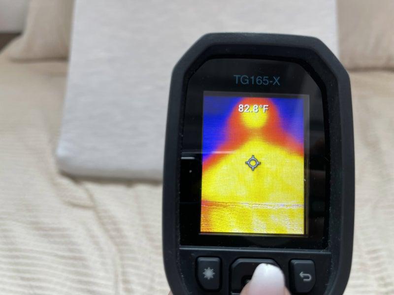 A thermal gun pointed at a Helix Wedge Pillow reading a temperature of 82.8 degrees