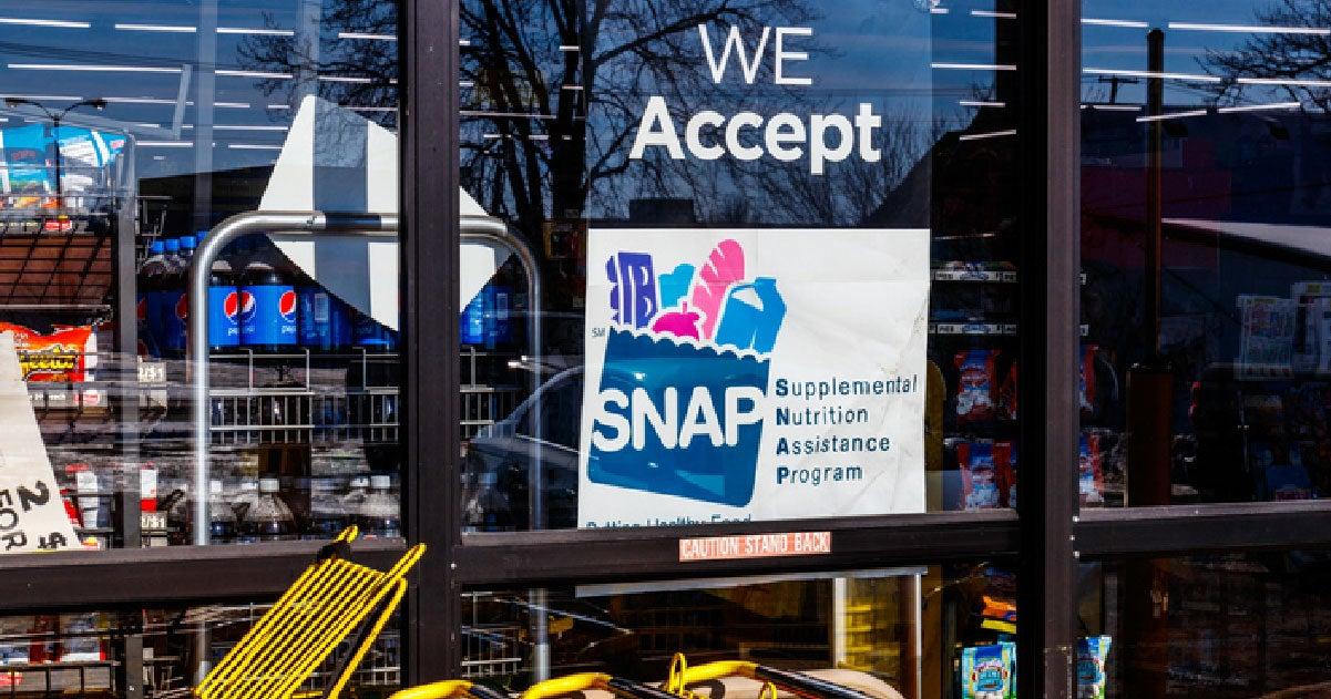 Grocery store window with sign saying We Accepts SNAP Supplemental Nutrition Assistance Program