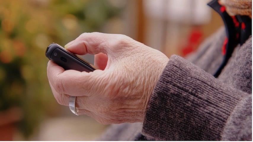 Close-up of a hand pressing a button on a medical alert device