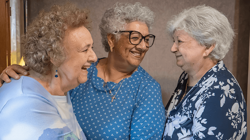 three gray-haired sisters laughing together